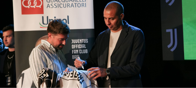 Claudio Messa firma una maglia durante un evento serale
